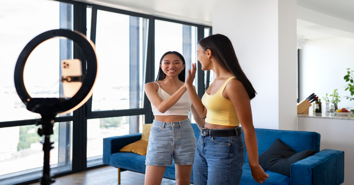 Alt Text: Girls recording a TikTok video highlighting the importance of timing in social media engagement.