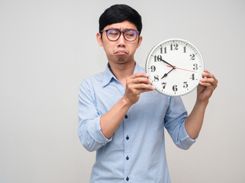 A man looking at a clock, symbolising the significance of timing in maximising TikTok engagement.